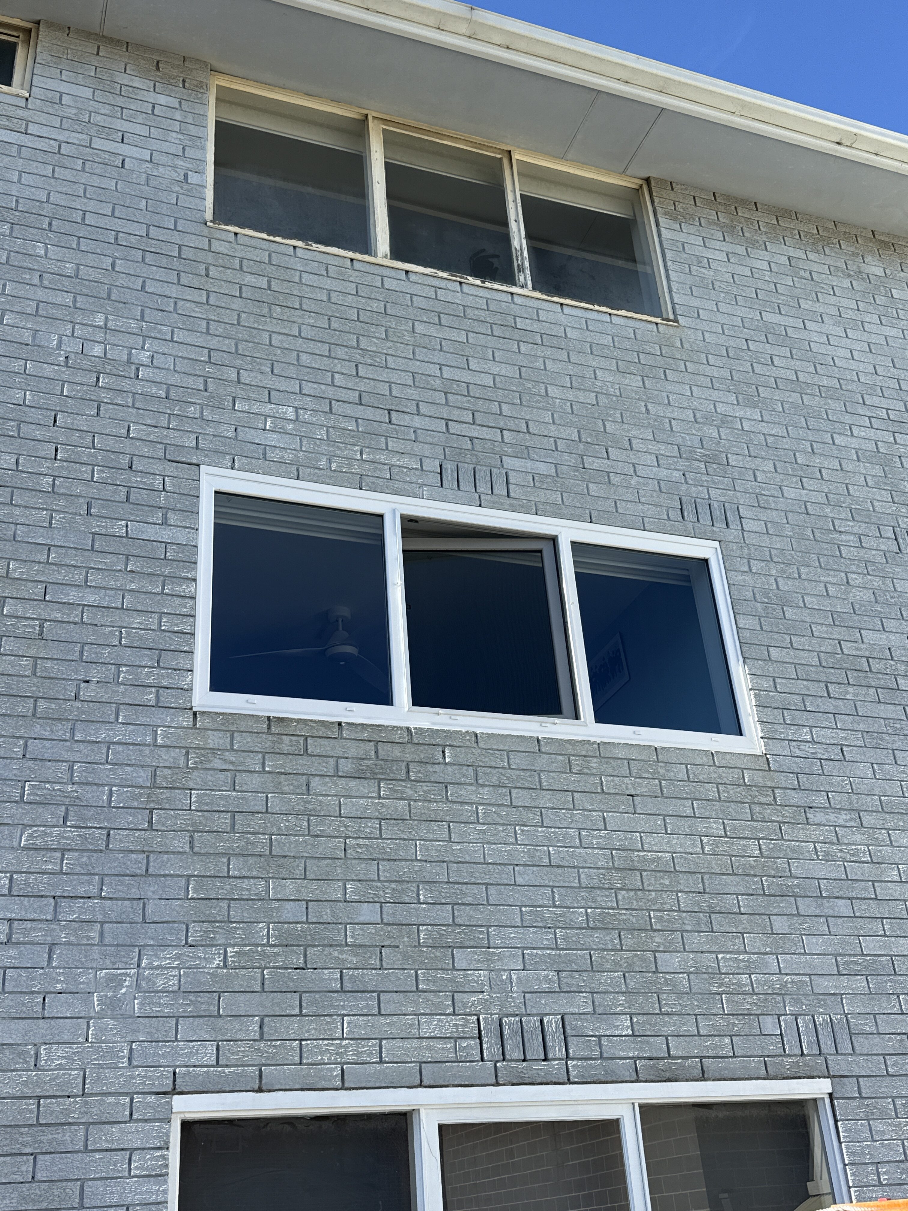 A new white uPVC double glazed window installed into an existing painted-brick Richmond home, with an older timber window above still to be replaced